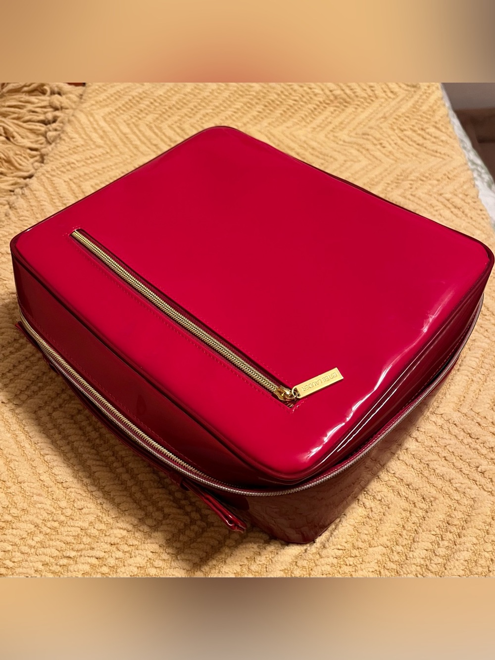 Estée Lauder glossy red travel cosmetic case with gold-tone zipper